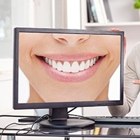 Person pointing at monitor showing person smiling