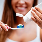 Woman squeezing toothpaste onto toothbrush