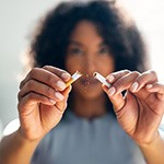 Woman snapping cigarette in half