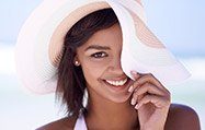 Lady wearing sunhat smiling mischievously