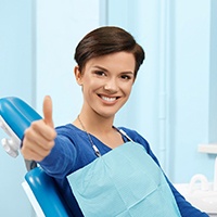 Patient giving thumbs up for her cosmetic dentist