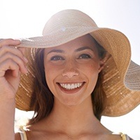 Lady hloding sunhat with glowing smile