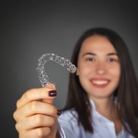 woman holding clear aligner