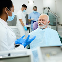 mature man talking to dentist about dentures in Huntington Beach 