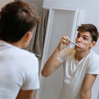 Man brushing his teeth to prevent dental emergencies in Huntington Beach