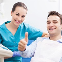 Man in dental chair giving thumbs up