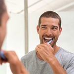 Young man brushing his dental implants in Huntington Beach