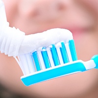 Close-up of toothpaste being applied to toothbrush