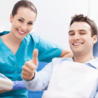 Man in dental chair giving thumbs up