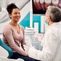 Patient smiling while dentist reviews his checkup findings
