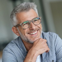 Man sitting down and smiling with glasses