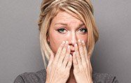 Anguished woman holding hands to mouth