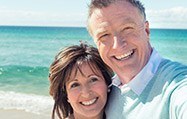 Senior Couple hugging by the beach smiling