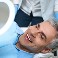 Man with veneers smiling in dental mirror