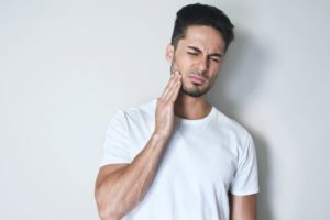 man holding jaw in pain