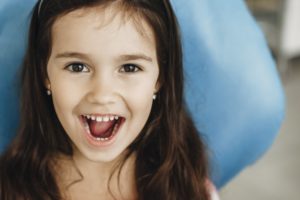 a little girl showing off her teeth 