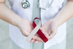 a dentist holding an oral cancer awareness month ribbon