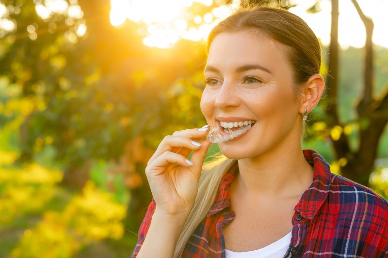 Woman in the sun putting on her Invisalign